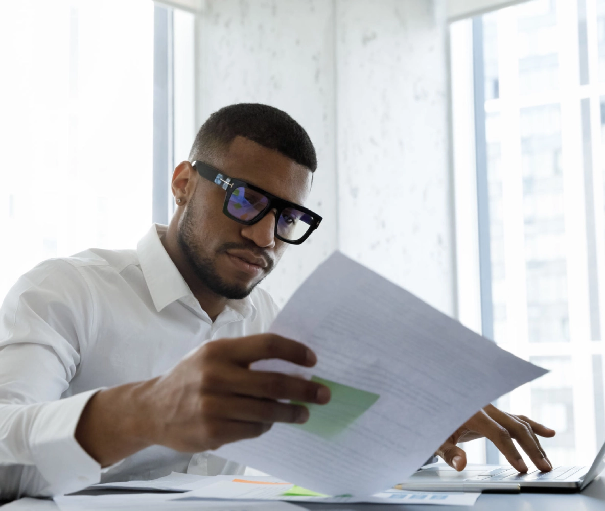 Man reviewing documents at office desk.